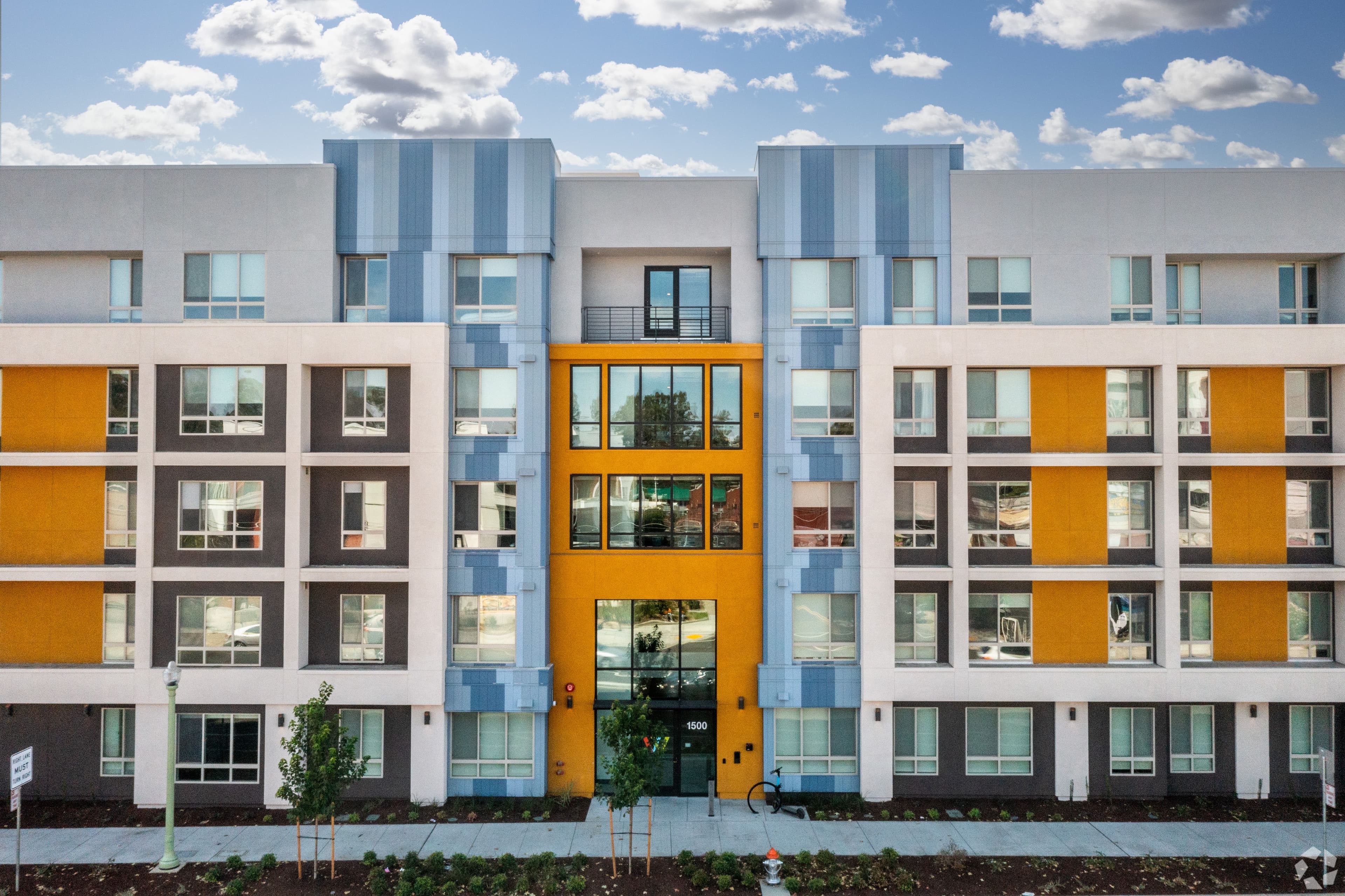 Wexler’s front elevation, a five-story student housing building with white, blue and gold panels and a gold-framed entry