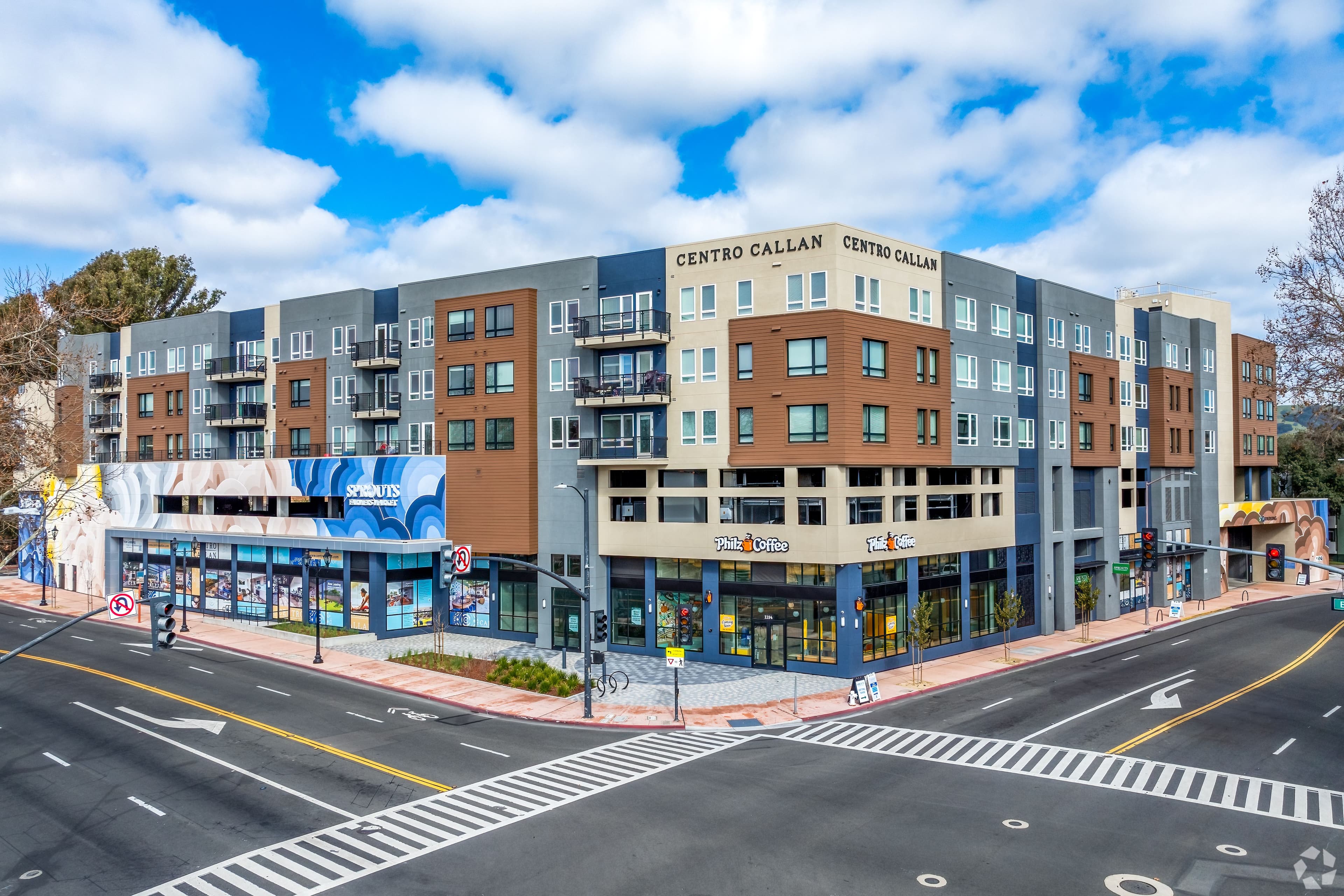 Centro Callan from across the intersection, a five-story building with ground-floor retail and a mural at the corner