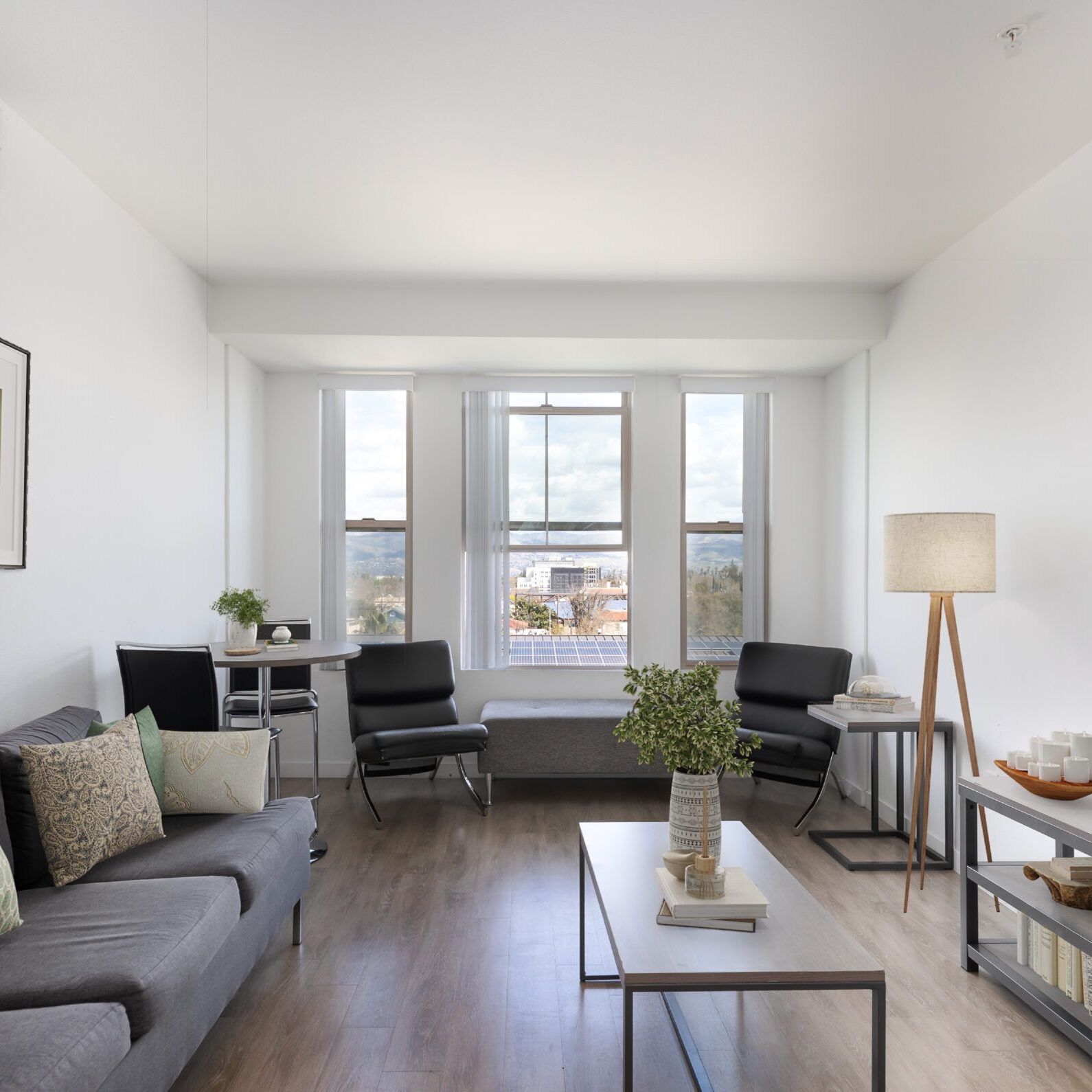Living room with grey sofas and a bay window with a city view