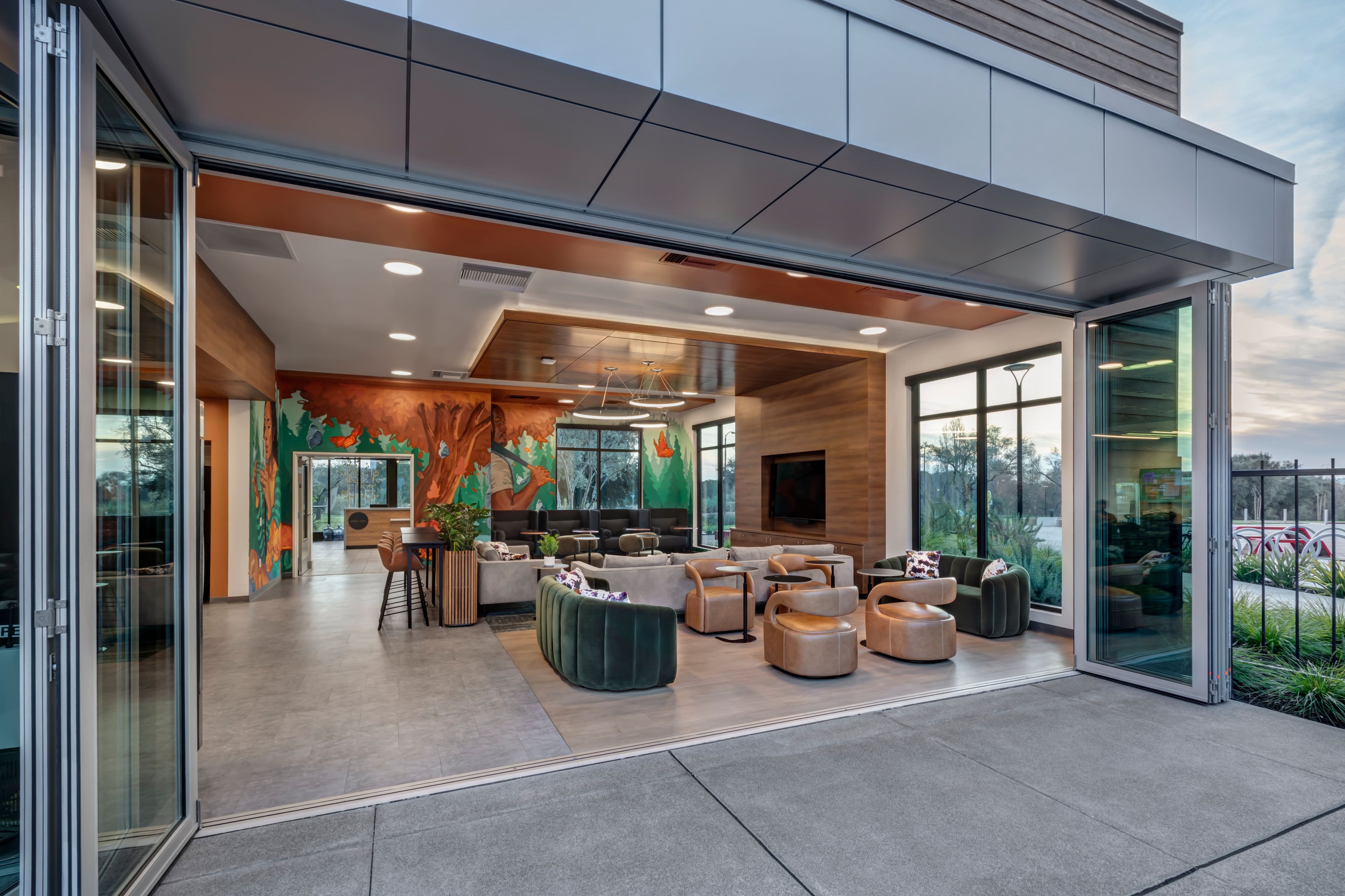 Clubroom seen through fully opened glass walls from the patio