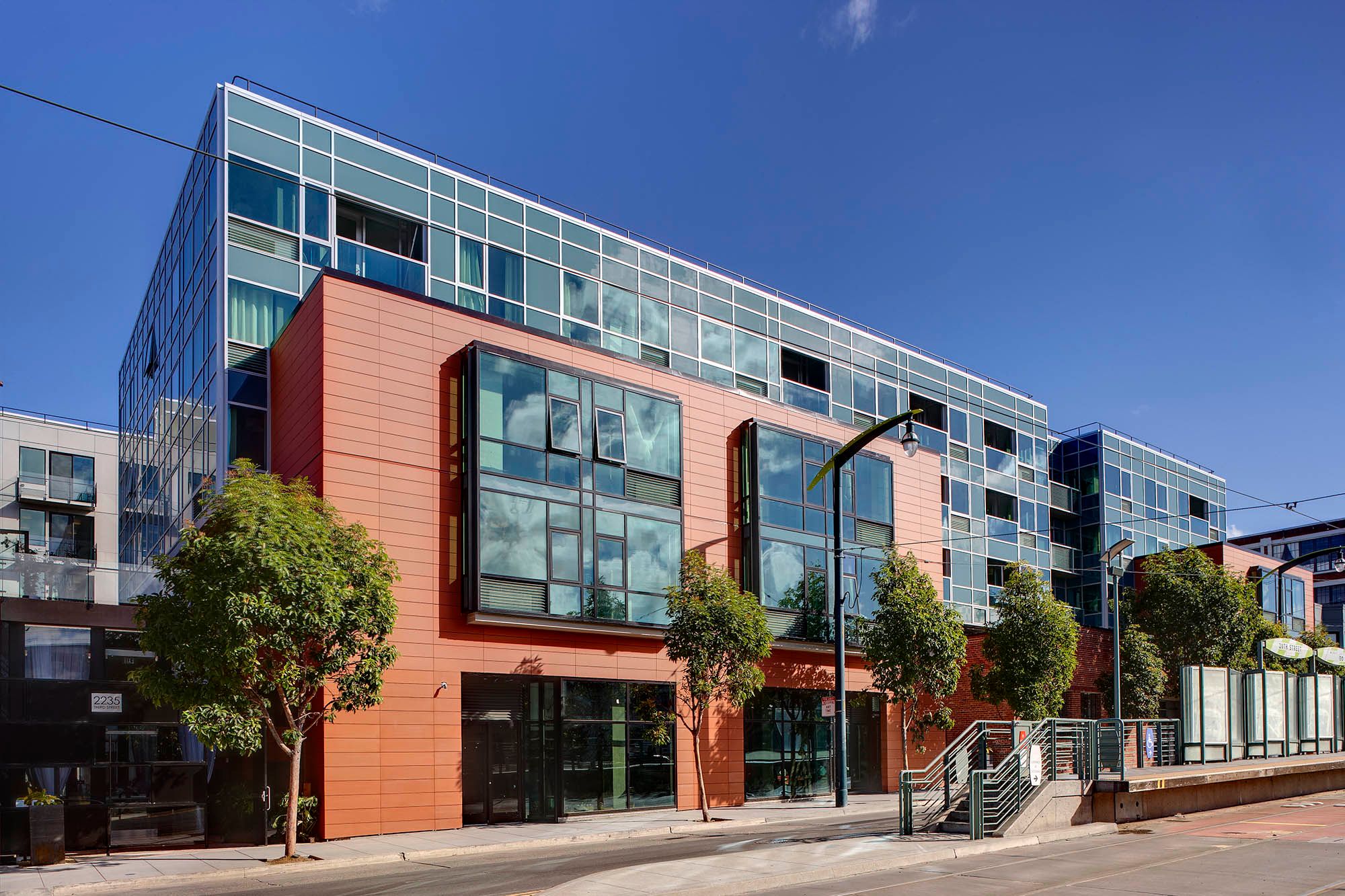Potrero Launch, a five-story building with orange and blue-grey facades and ground-floor commercial space