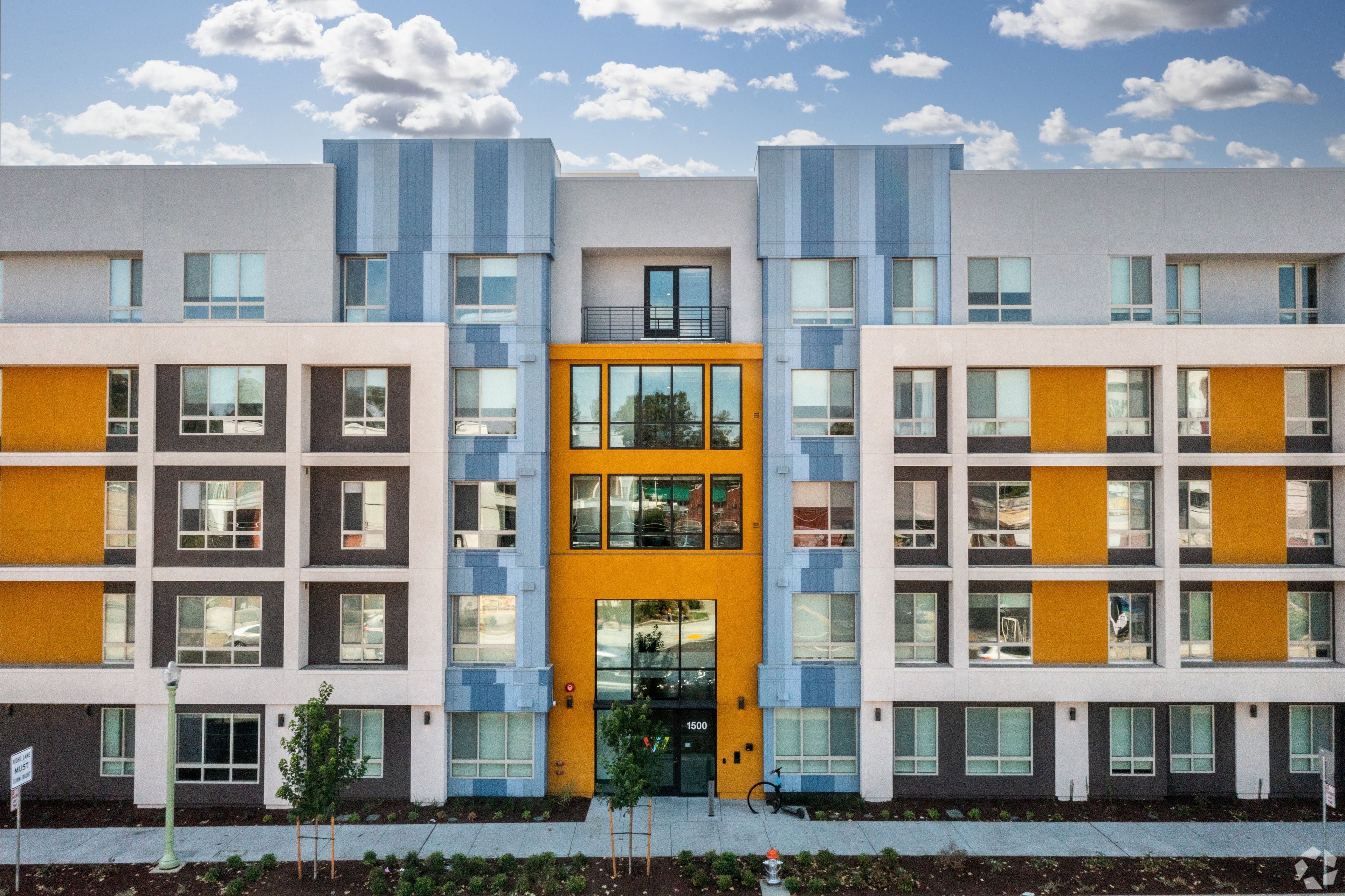 Wexler’s front elevation, a five-story student housing building with white, blue and gold panels and a gold-framed entry