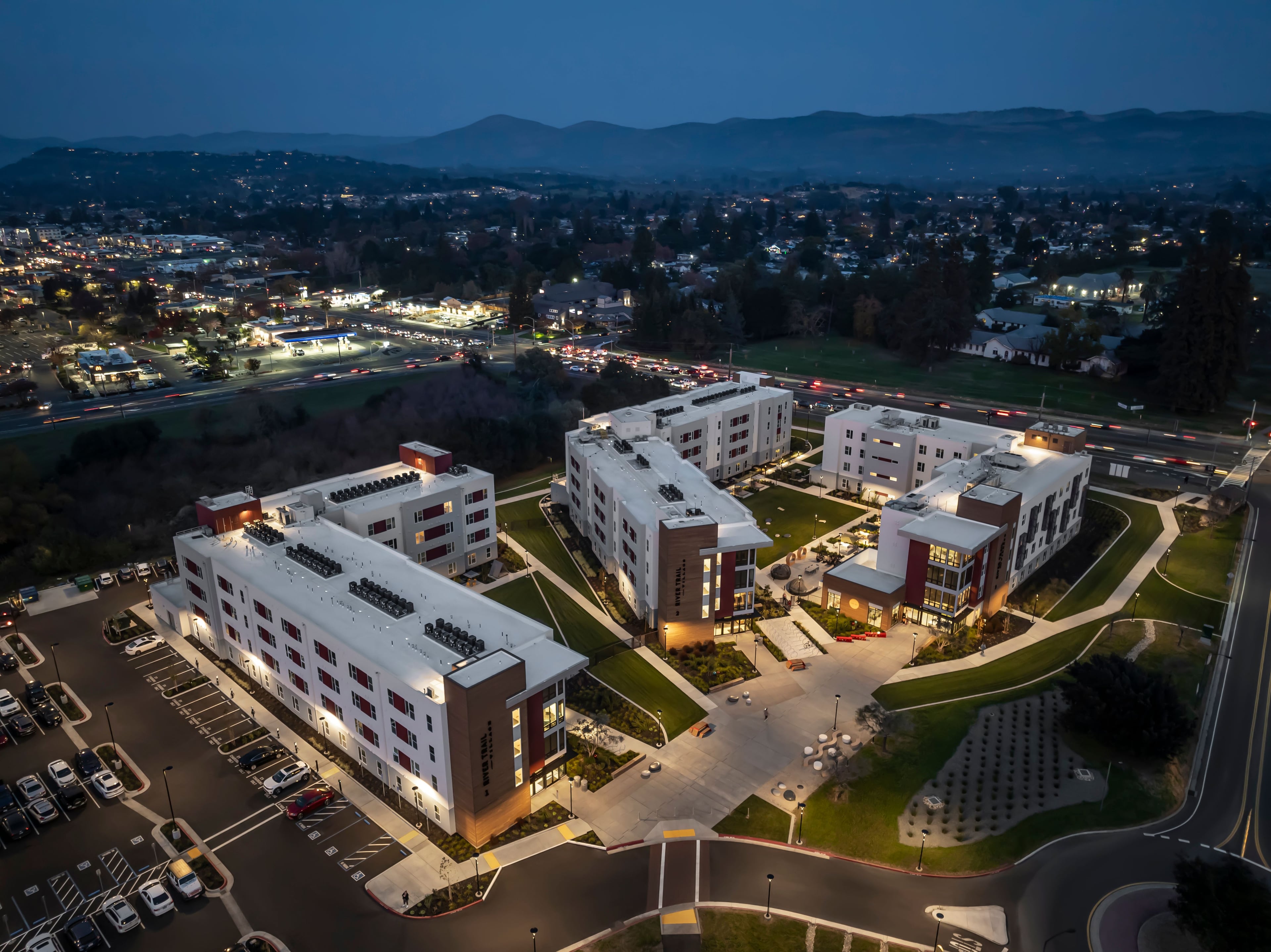 Aerial view at dusk of the three buildings and parking with Napa hills behind