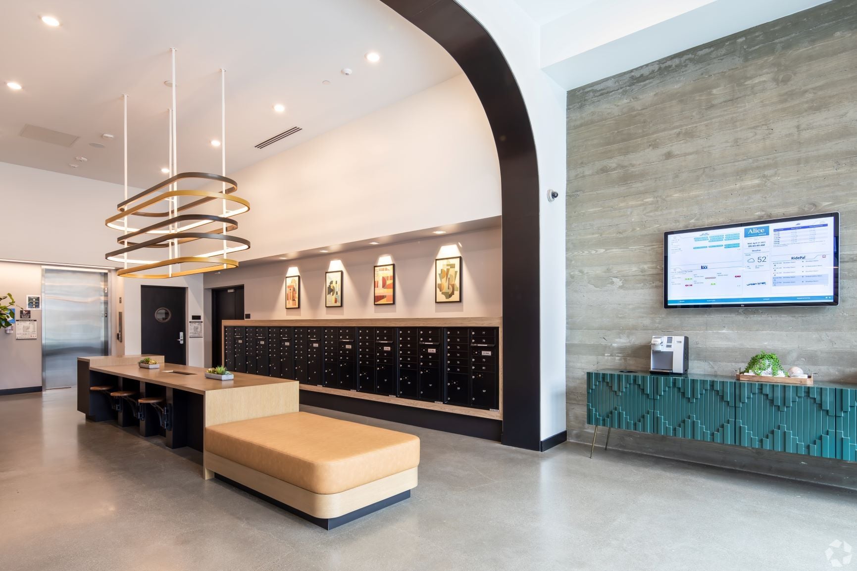 Lobby with mailboxes, ring pendant lights, and a curved concrete archway