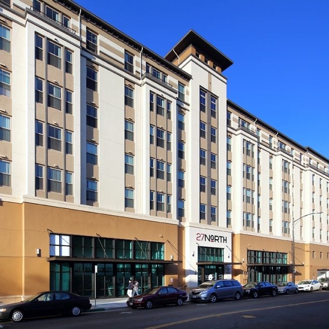 27 North, a seven-story tan building with a corner tower and the 27 North sign over the entrance