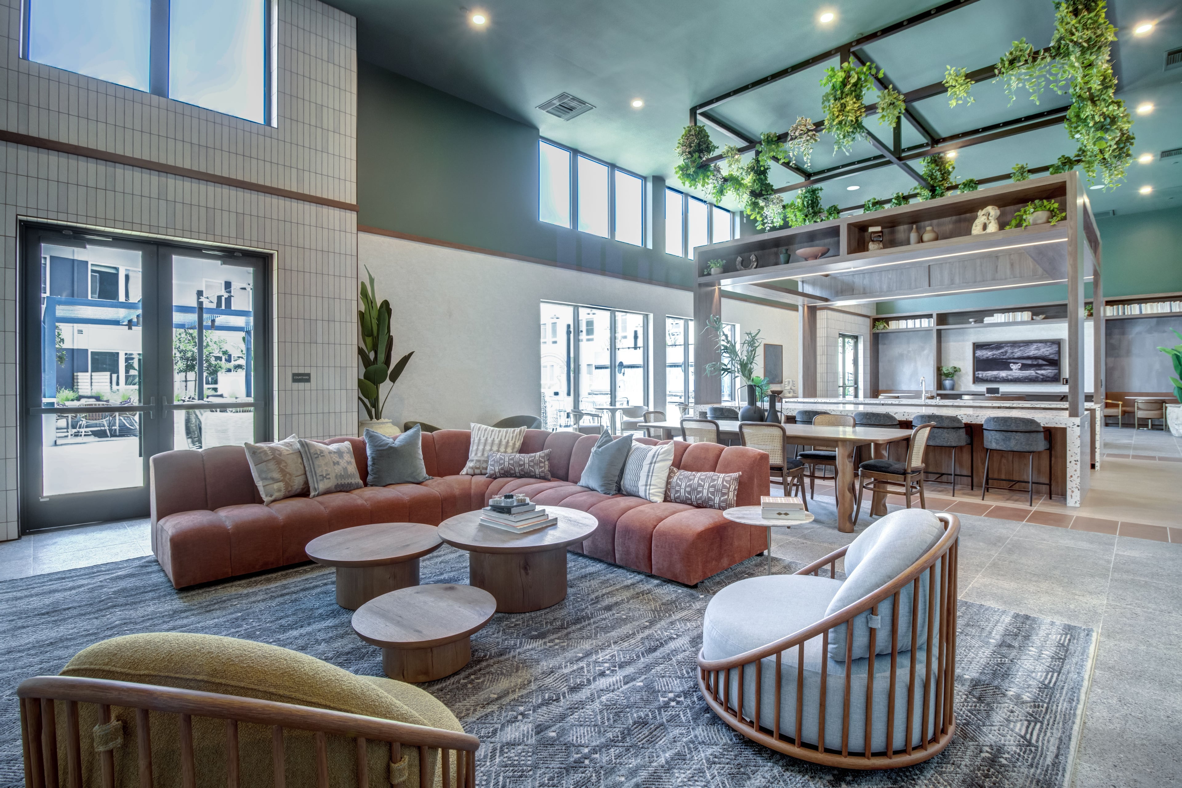 Resident lounge with a rust-colored sectional and a kitchen along the far wall